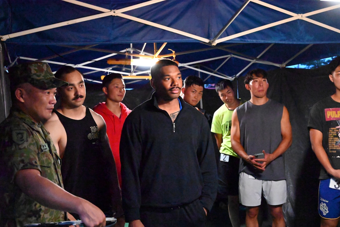 Bodybuilders listening to instructions before taking the stage for the competition.