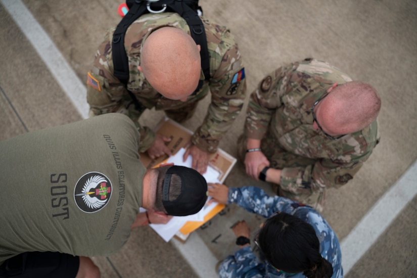 A U.S. Special Operations Forces Operator retrieves a cold chain blood resupply shipment from U.S. Army Sgt. 1st Class Eric Jimenez, medical logistics noncommissioned officer; Royal Australian Air Force Flt. Lt. Pooja Sapkota, scientific officer and pathology advisor, both with the Combined Joint Theatre Medical Component; and a member of the U.S. Air Force’s C-17 Globemaster crew, 535th Airlift Squadron, in Queensland, Australia, during Exercise Talisman Sabre 2025 on July 22, 2025.