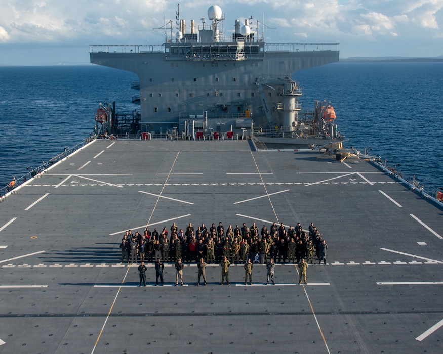 Royal Australian Navy Sailors, assigned to Australian Mine Warfare Team and Maritime Geospatial Warfare Unit; Royal New Zealand Navy Sailors, assigned to HMNZS Matataua; and U.S. Navy Sailors and Military Sealift Command civil service mariners, assigned to the Lewis B. Puller-class expeditionary sea base USS John L. Canley (ESB 6), pose for a group photo on the flight deck of the ship off the coast of Australia during Talisman Sabre, July 18, 2025.