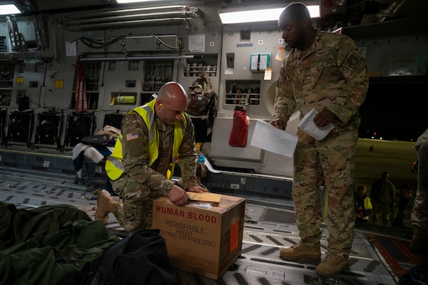 U.S. Army Sgt. 1st Class Eric Jimenez, medical logistics noncommissioned officer, 18th Theater Medical Command, Combined Joint Theatre Medical Component, signs documents to retrieve blood products, a first-of-its-kind mission, from a U.S. Air Force C-17 Globemaster in Queensland, Australia, during Exercise Talisman Sabre 2025 on July 21, 2025.