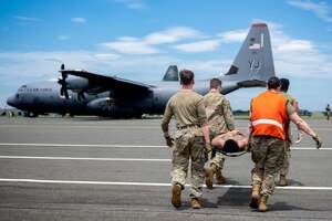 U.S. Air Force Airmen assigned to the 35th Operational Medical Readiness Squadron carry a simulated patient to a U.S. Air Force C-130J Super Hercules for a bilateral aeromedical evacuation training event during exercise Resolute Force Pacific (REFORPAC) 2025.