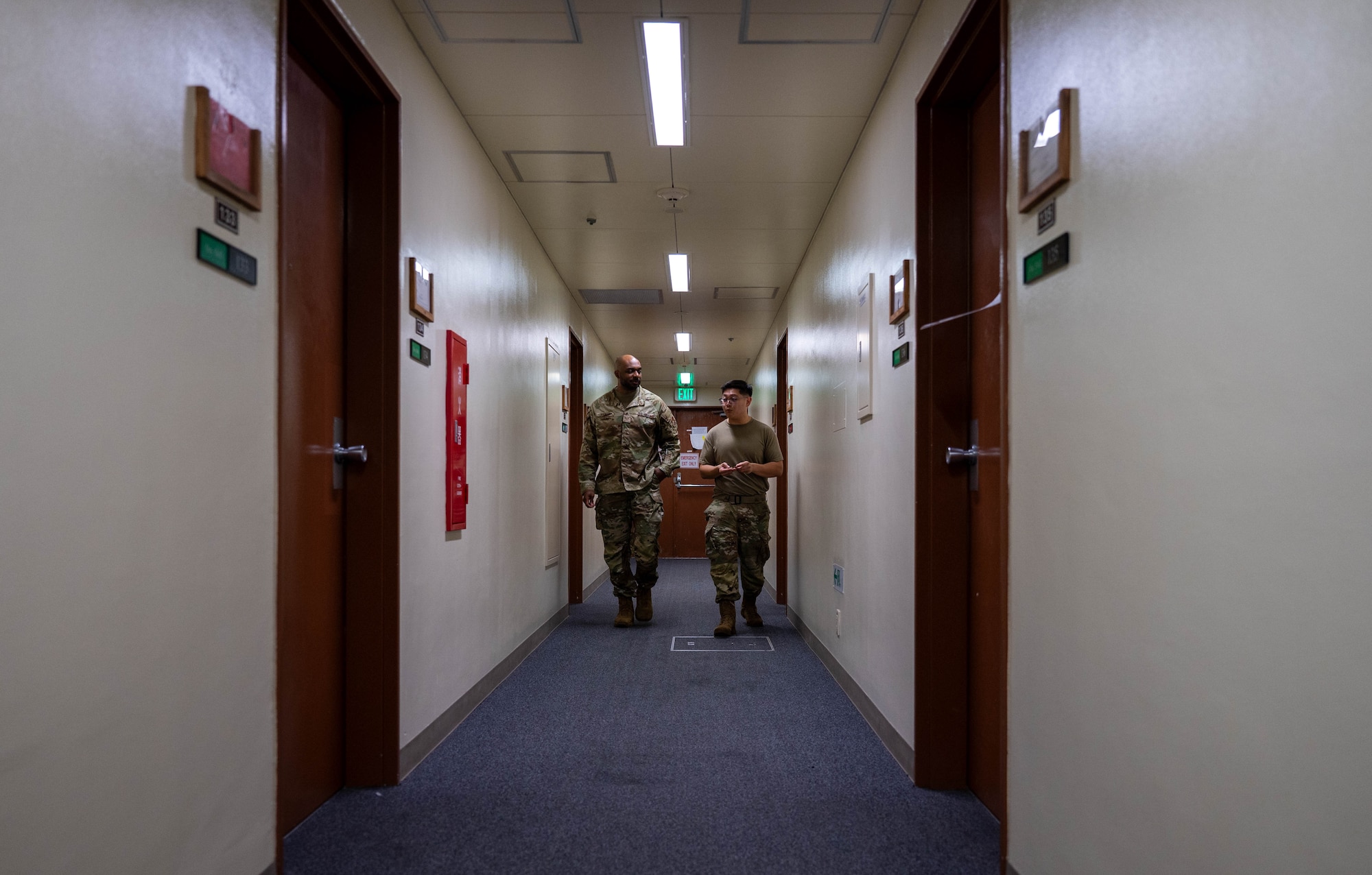 Two service members walk down the hall.