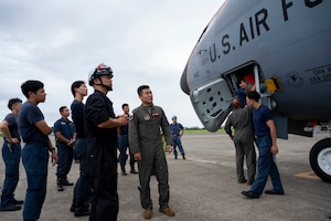 A military member speaks to Japanese firefighters.