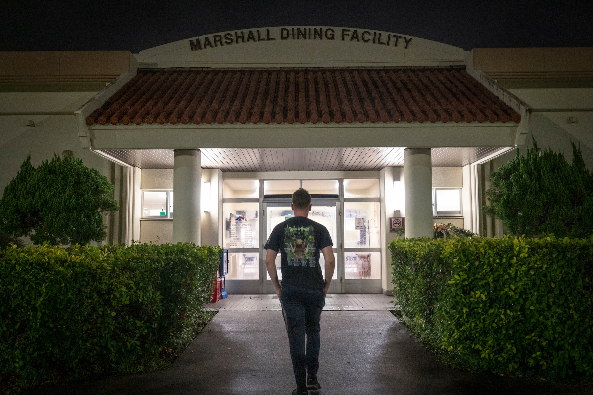 U.S. Air Force Airman 1st Class Logan Hilton, 718th Civil Engineer Squadron electrical engineer, enters the Marshall Dining Facility during the midnight service on Kadena Air Base, Japan, July 24, 2025.