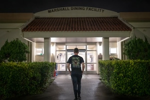 U.S. Air Force Airman 1st Class Logan Hilton, 718th Civil Engineer Squadron electrical engineer, enters the Marshall Dining Facility during the midnight service on Kadena Air Base, Japan, July 24, 2025.