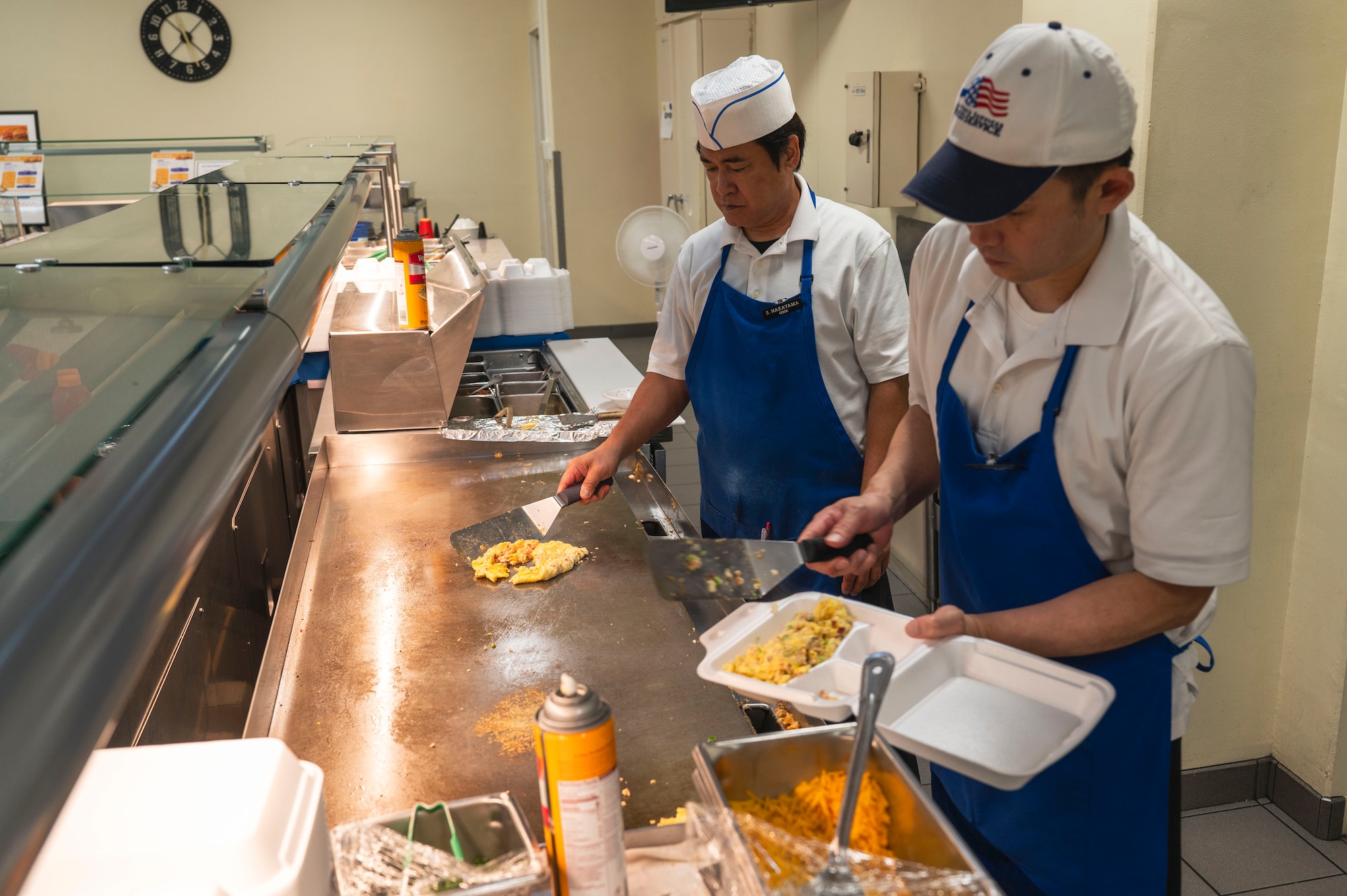 Nakaya Ma, left, and Ishikawa Yuzuru, 18th Force Support Squadron food services cooks, prepare food during the midnight service at the Marshall Dining Facility on Kadena Air Base, Japan, July 24, 2025.