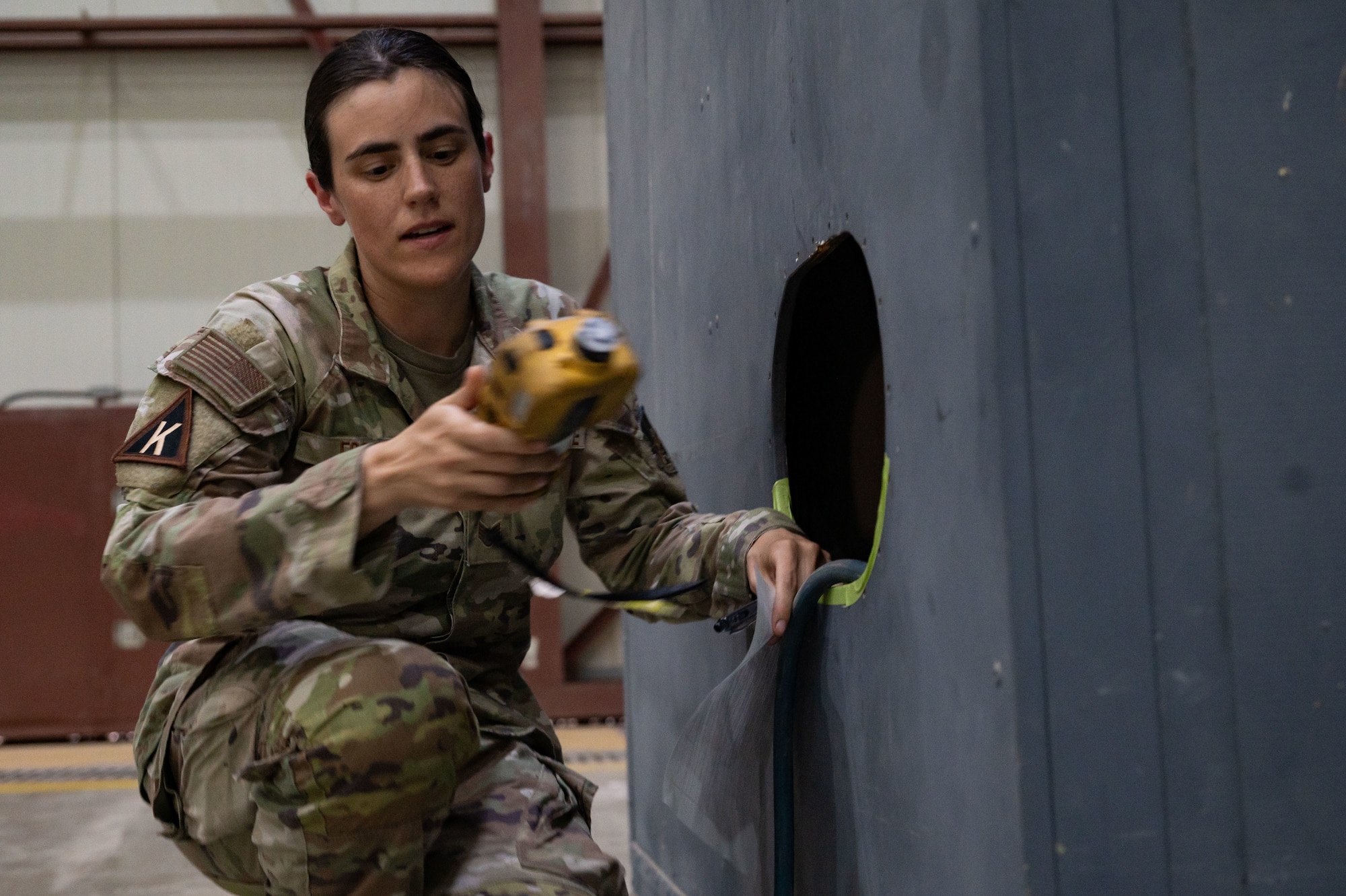 U.S. Air Force Staff Sgt. Megan Fogg, 379th Expeditionary Aircraft Maintenance Squadron fuels systems technician, uses a photoionization detector during a confined-space extraction exercise within the U.S. Central Command area of responsibility, July 21, 2025. The exercise simulated an Airman fainting in a confined space due to fuel vapors. (U.S. Air Force photo by Senior Airman Dieondiere Jefferies)