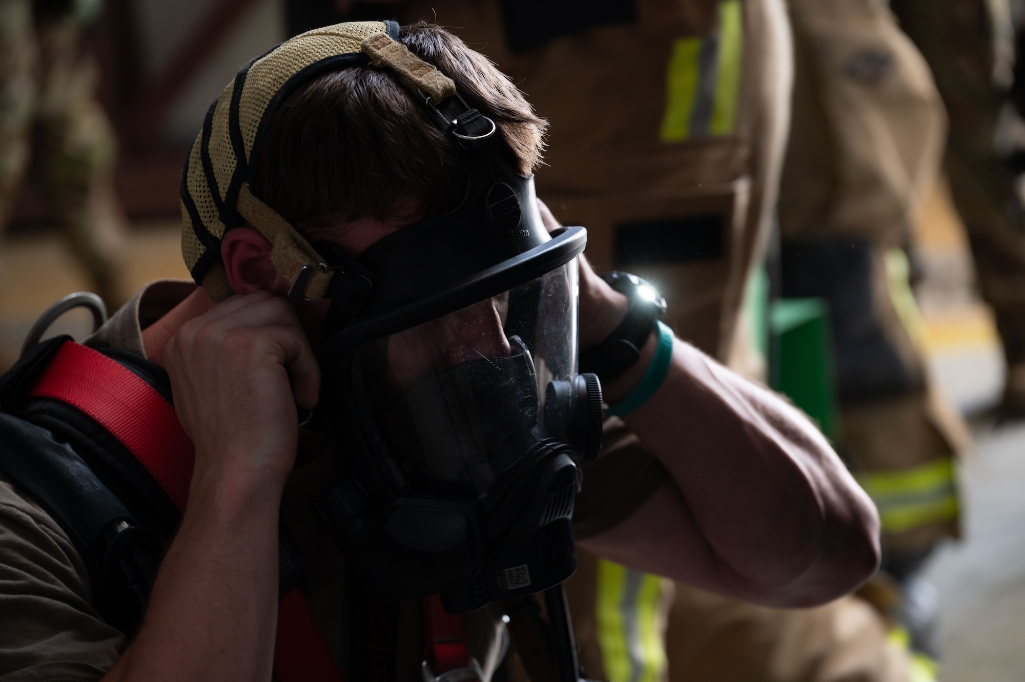 U.S. Air Force Senior Airman Mason Allen, 379th Expeditionary Civil Engineer Squadron firefighter, dons a breathing apparatus during a confined-space extraction exercise within the U.S. Central Command area of responsibility, July 21, 2025. The 379th ECES are responsible for ensuring the safety of others on base and responding to emergencies. (U.S. Air Force photo by Senior Airman Dieondiere Jefferies)