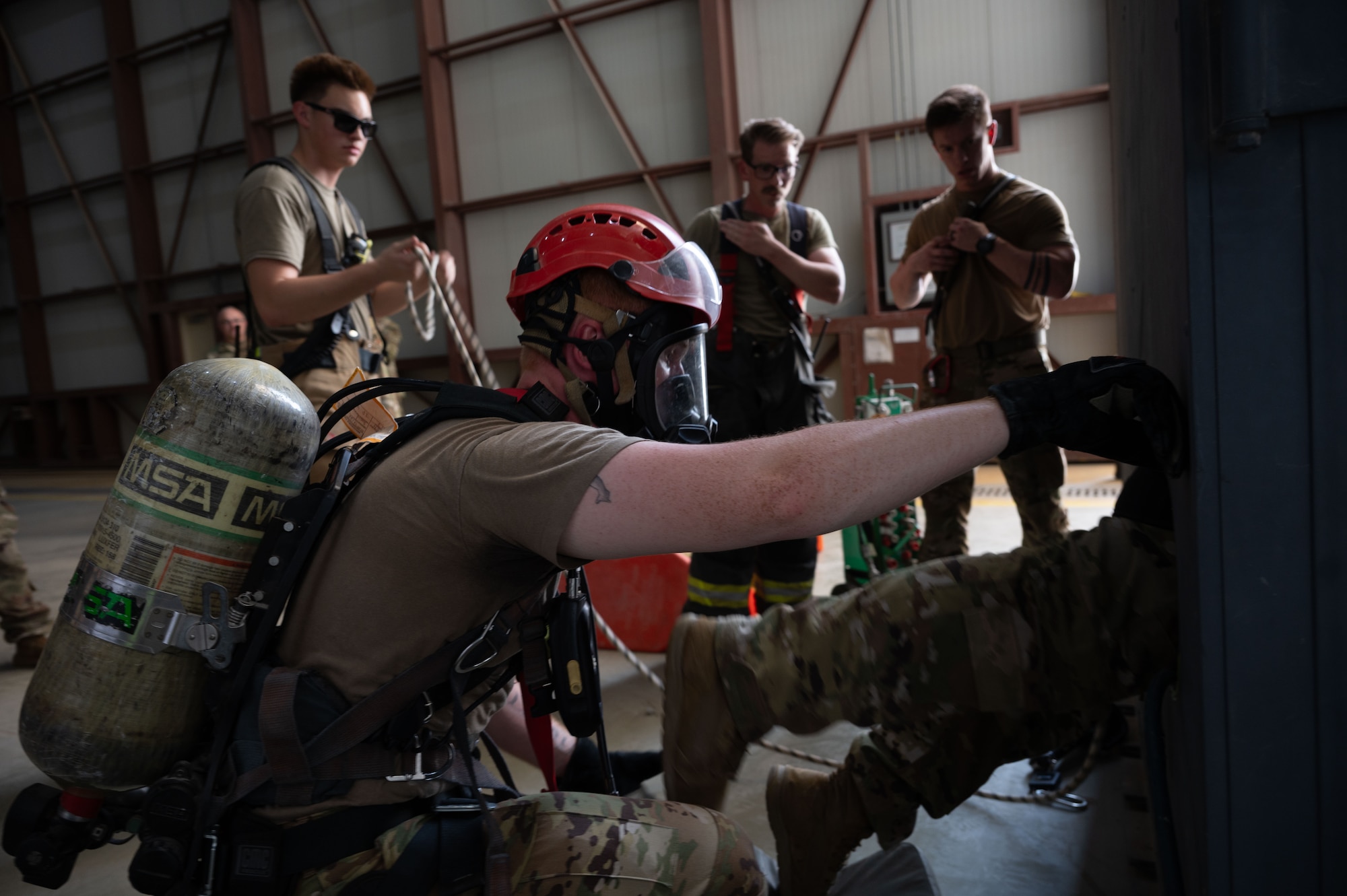 Firefighters assigned to the 379th Expeditionary Civil Engineer Squadron assist during a confined space extraction exercise within the U.S. Central Command area of responsibility, July 21, 2025. The 379th ECES is responsible for ensuring the safety of others on base and responding to emergencies. (U.S. Air Force photo by Senior Airman Dieondiere Jefferies)