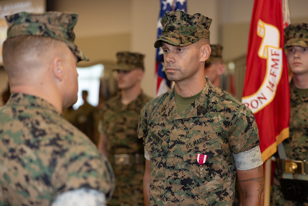 U.S. Marine Corps Lt. Col. Nicholas Verta, left, from Pennsylvania, commanding officer of Marine Aviation Logistics Squadron 14, Marine Aircraft Group 14, 2nd Marine Aircraft Wing, awards the Meritorious Service Medal to Sgt. Maj. Donald Swanner, from Maryland, former command senior enlisted leader, MALS-14, during a relief and appointment ceremony at Marine Corps Air Station Cherry Point, North Carolina, July 23, 2025. The ceremony represented a transfer of responsibility, authority, and accountability from Swanner to Sgt. Maj. Christianna Wolford. (U.S. Marine Corps photo by Lance Cpl. Orlanys Diaz Figueroa)