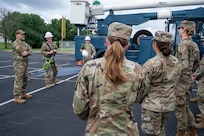 From left, U.S. Air Force Master Sgt. Alejandro Alba, operations engineering superintendent, Senior Airman Brady Steelman, electrical systems journeyman, and Staff Sgt. Alex Vanskiver, an electrical systems supervisor, all from the 11th Civil Engineer Squadron, brief cadets from the U.S. Air Force Academy on the aerial lift truck at Joint Base Anacostia-Bolling, Washington, D.C., July 15, 2025. Cadets visited JBAB as part of USAFA’s Summer Operations program to learn more about officer life and the operational Air Force. (U.S. Air Force photo by Hayden Hallman)