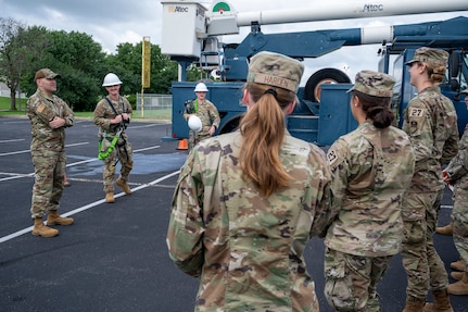 From left, U.S. Air Force Master Sgt. Alejandro Alba, operations engineering superintendent, Senior Airman Brady Steelman, electrical systems journeyman, and Staff Sgt. Alex Vanskiver, an electrical systems supervisor, all from the 11th Civil Engineer Squadron, brief cadets from the U.S. Air Force Academy on the aerial lift truck at Joint Base Anacostia-Bolling, Washington, D.C., July 15, 2025. Cadets visited JBAB as part of USAFA’s Summer Operations program to learn more about officer life and the operational Air Force. (U.S. Air Force photo by Hayden Hallman)
