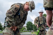 U.S. Air Force Academy Cadet Caitlyn Budd dons a safety harness during a demonstration of 11th Civil Engineer Squadron equipment at Joint Base Anacostia-Bolling, Washington, D.C., July 15, 2025. Cadets visited JBAB as part of USAFA’s Summer Operations program to learn more about officer life and the operational Air Force. (U.S. Air Force photo by Hayden Hallman)