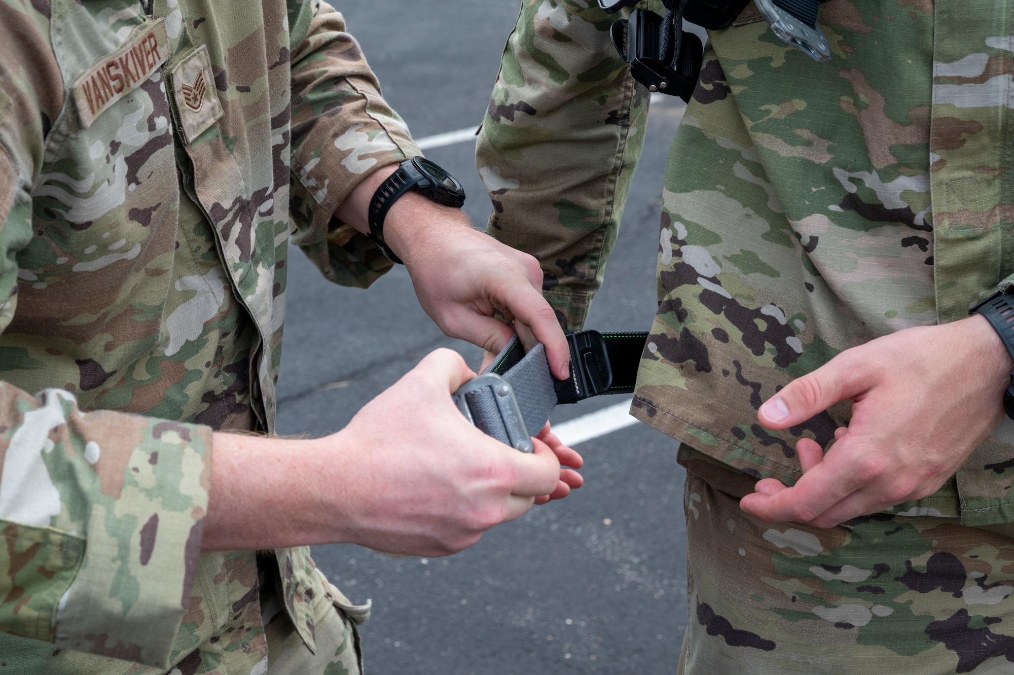 U.S. Air Force Staff Sgt. Alex Vanskiver, left, an electrical systems supervisor for the 11th Civil Engineer Squadron, assists U.S. Air Force Academy Cadet Bradford Hurt with donning a safety harness during a demonstration of 11th Civil Engineer Squadron equipment at Joint Base Anacostia-Bolling, Washington, D.C., July 15, 2025. Cadets visited JBAB as part of USAFA’s Summer Operations program to learn more about officer life and the operational Air Force. (U.S. Air Force photo by Hayden Hallman)