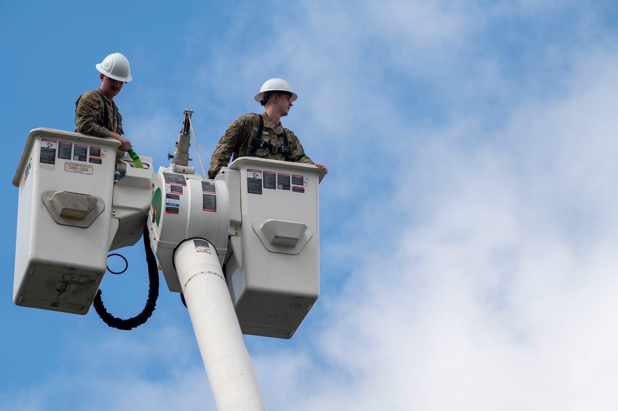U.S. Air Force Staff Sgt. Alex Vanskiver, left, an electrical systems supervisor for the 11th Civil Engineer Squadron, assists U.S. Air Force Academy Cadet Bradford Hurt with donning a safety harness during a demonstration of 11th Civil Engineer Squadron equipment at Joint Base Anacostia-Bolling, Washington, D.C., July 15, 2025. Cadets visited JBAB as part of USAFA’s Summer Operations program to learn more about officer life and the operational Air Force. (U.S. Air Force photo by Hayden Hallman)
