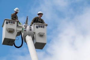 U.S. Air Force Staff Sgt. Alex Vanskiver, left, an electrical systems supervisor for the 11th Civil Engineer Squadron, assists U.S. Air Force Academy Cadet Bradford Hurt with donning a safety harness during a demonstration of 11th Civil Engineer Squadron equipment at Joint Base Anacostia-Bolling, Washington, D.C., July 15, 2025. Cadets visited JBAB as part of USAFA’s Summer Operations program to learn more about officer life and the operational Air Force. (U.S. Air Force photo by Hayden Hallman)