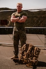 A U.S. Marine with 1st Battalion, 5th Marine Regiment, poses for a photo while standing next to a new main pack frame during a limited user evaluation at Marine Corps Base Camp Pendleton, Calif.