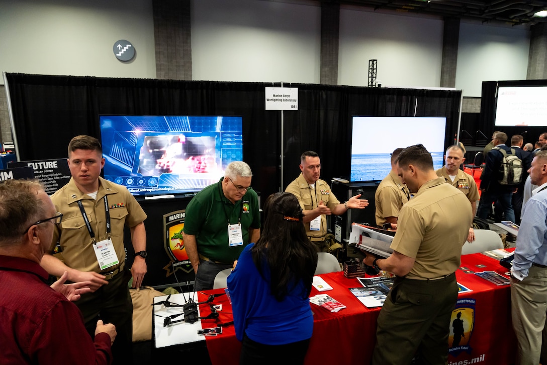 Members of the Marine Corps Warfighting Laboratory, man MCWL's booth during Modern Day Marine at the Walter E. Washington Convention Center, Washington D.C., April 30th, 2025. Modern Day Marine is a military exposition exclusively organized for the Marine Corps to showcase the newest technology and warfighting innovations from amphibious assault vehicles to drones and more. (U.S. Marine Corps photo by Connor Taggart)