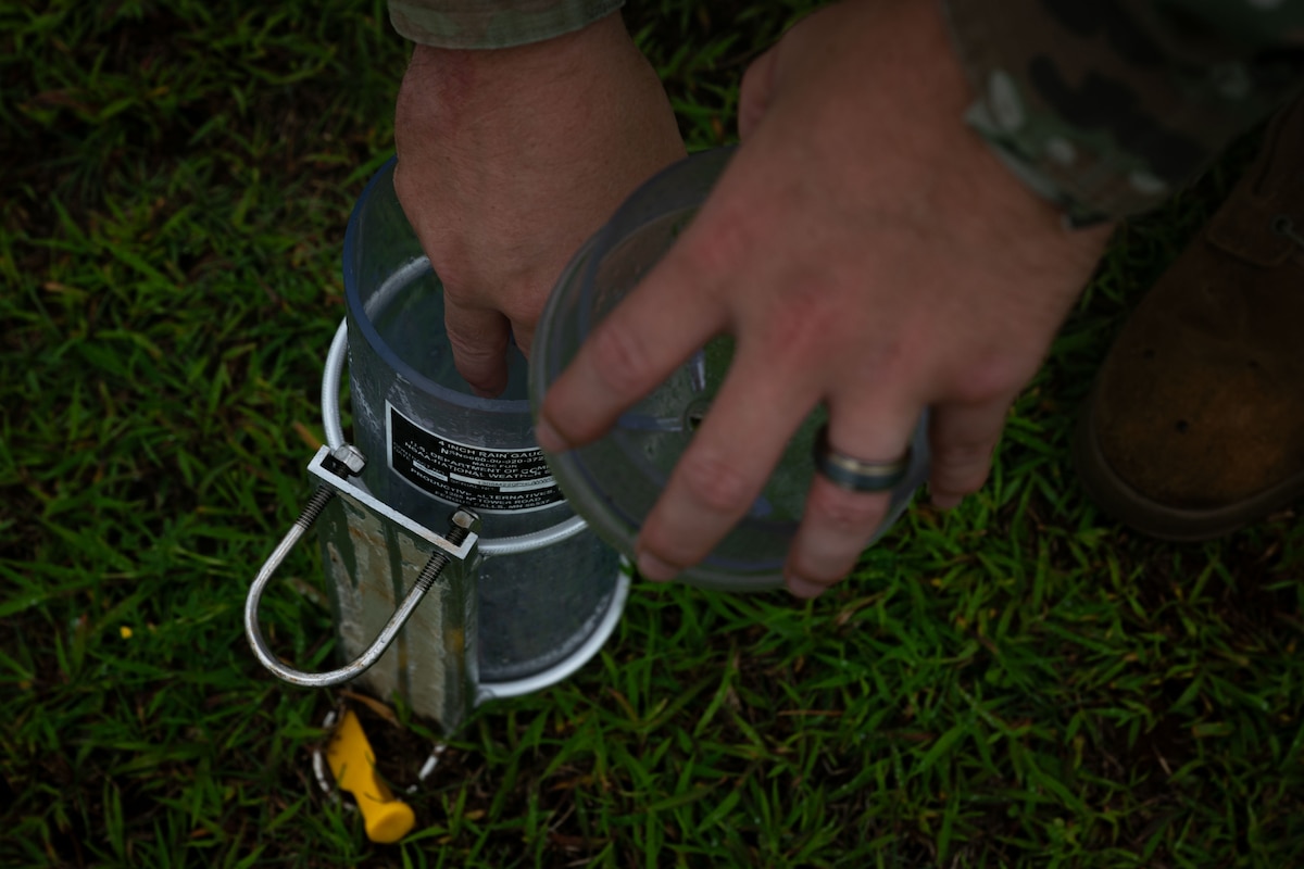 U.S. Air Force Airman 1st Class Nicholas Clark, 36th Operations Support Squadron weather apprentice and forecaster, secures a rain gauge to measure precipitation during exercise Resolute Force Pacific 2025, at Andersen Air Force Base, Guam, July 25, 2025. REFORPAC, part of the first-in-a-generation Department-Level Exercise series, trains Airmen to operate in a contested, dynamic environment while executing real-time force projection and joint interoperability. (U.S. Air Force photo by Staff Sgt. Jasmine M. Barnes)
