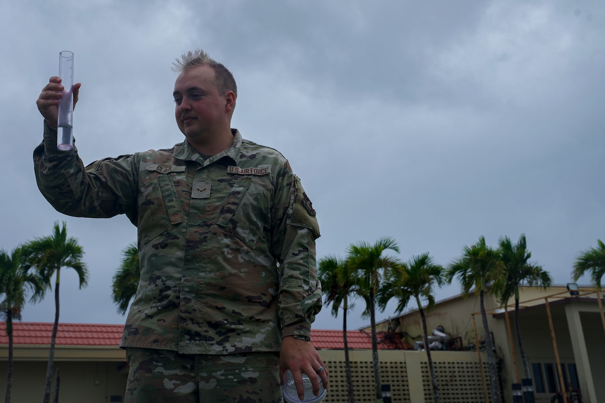 U.S. Air Force Airman 1st Class Nicholas Clark, 36th Operations Support Squadron weather apprentice and forecaster, inspects a rain gauge to measure precipitation during exercise Resolute Force Pacific 2025, at Andersen Air Force Base, Guam, July 25, 2025. REFORPAC, part of the first-in-a-generation Department-Level Exercise series, trains Airmen to operate in a contested, dynamic environment while executing real-time force projection and joint interoperability. (U.S. Air Force photo by Staff Sgt. Jasmine M. Barnes)