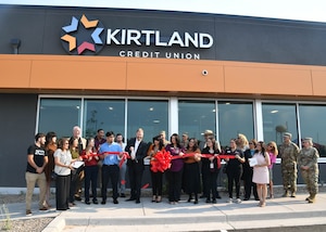 people cutting a ribbon in front of a building