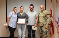 Angulo Gonzalez, a graduate of Woodbridge High School, and her parents, stand for a photograph with Brig. Gen. Leland D. Blanchard II, the Adjutant General (TAG) for the D.C. National Guard, during a Minuteman Scholarship ceremony at the D.C. Armory in Washington, D.C., on July 18, 2025. Gonzalez earned a four‑year scholarship to attend Virginia Tech and plans to commission into the Judge Advocate General’s Corps.