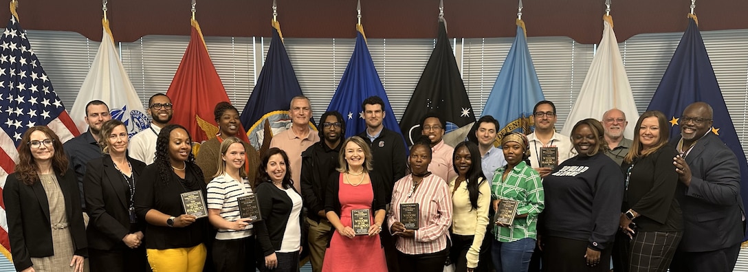 Group of people pose for a picture in conference room.