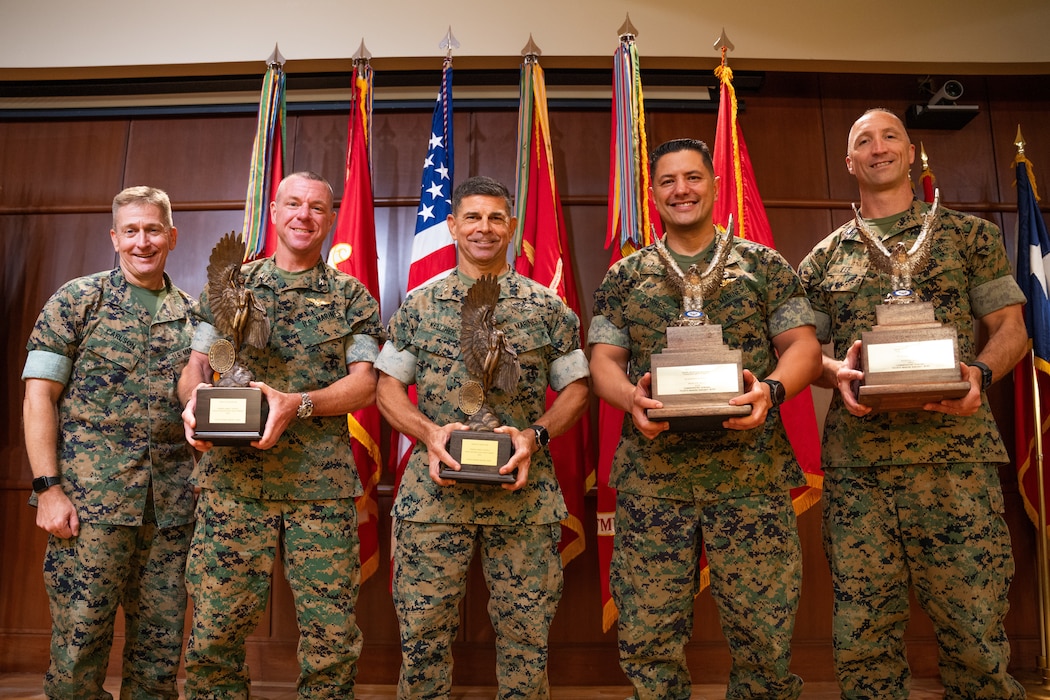 U.S. Marine Corps Maj. Gen. John Kelliher III (middle), commanding general of 4th Marine Aircraft Wing (4th MAW), stands with 4th MAW commanding officers during the awards presentation of the Admiral James S. Russell Naval Aviation Flight Safety Award for 2024 at Marine Corps Support Facility, New Orleans, Louisiana, July 24, 2025. The award recognizes the safety and mishap prevention practices that is cultured within military units while still effectively conducting flight operations. (U.S. Marine Corps photo by Cpl. Ujian Gosun)