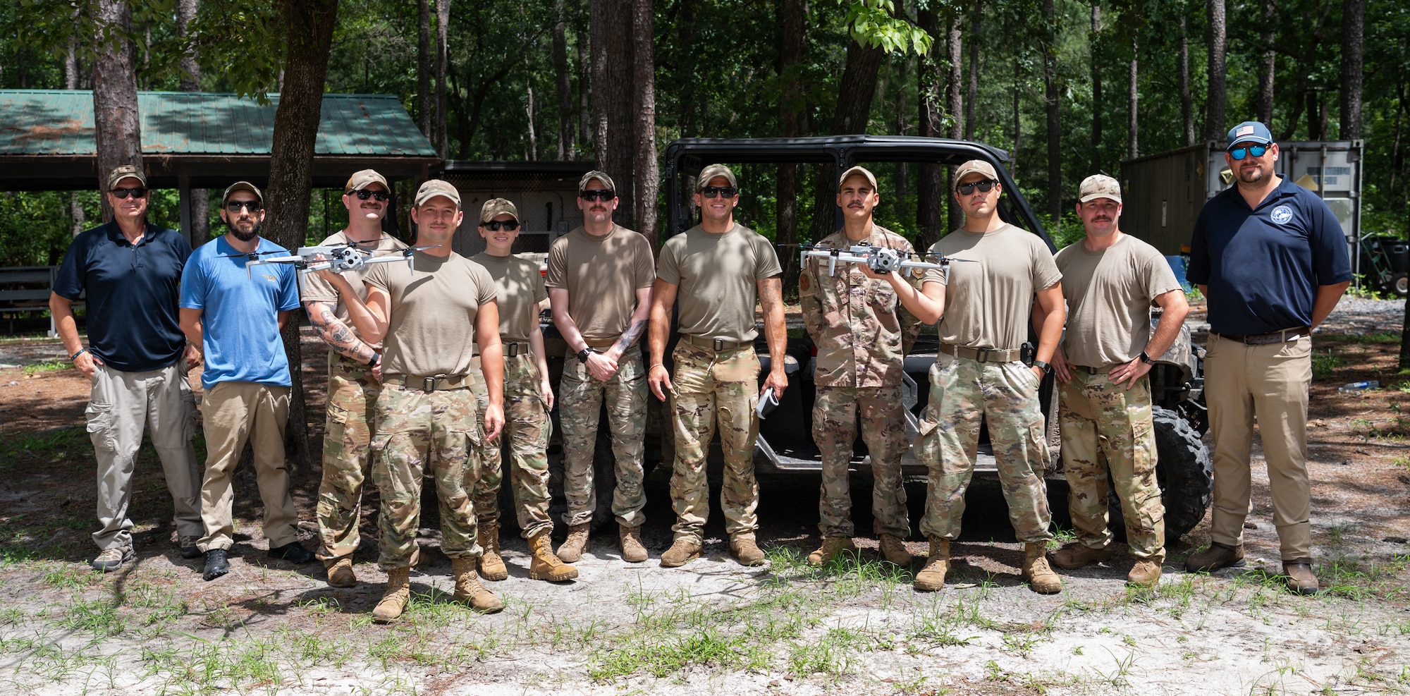 Airmen learn how to use a small drone in the woods
