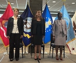 Three people standing for the national anthem.