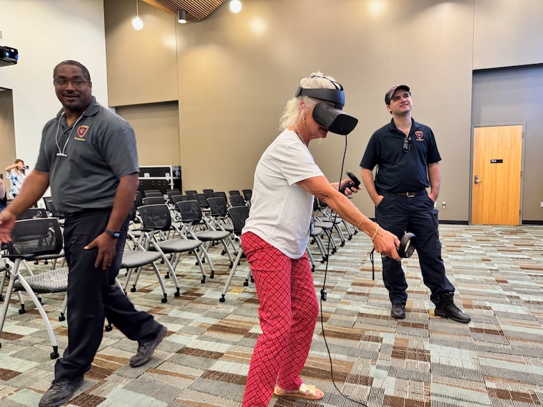 Employees take turns at practicing extinguishing a fire in a virtual reality.