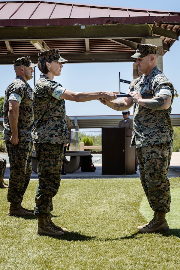 U.S. Marine Corps Lt. Col. Allison Hickman, commanding officer of I Marine Expeditionary Force Support Battalion, I Marine Expeditionary Force Information Group, presents the noncommissioned officer sword to Sgt. Maj. Zachariah Martin, the incoming command senior enlisted leader of I MSB, during a relief and appointment ceremony at Marine Corps Base Camp Pendleton, California, July 23, 2025. The relief and appointment ceremony signifies the transfer of responsibility and authority  from the outgoing to incoming command senior enlisted leader. (U.S. Marine Corps photo by Cpl. Peyton Kahle)