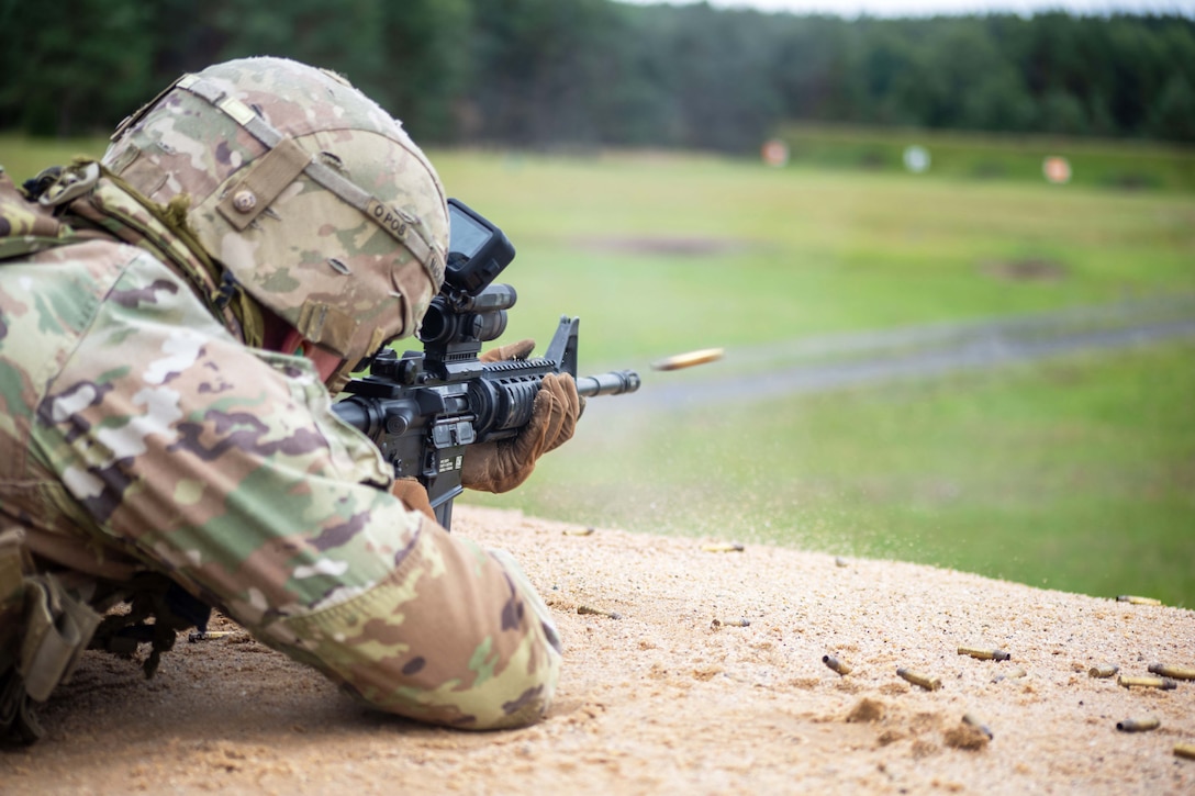 Ammo travels toward a field as a soldier lies on the ground holding a weapon.