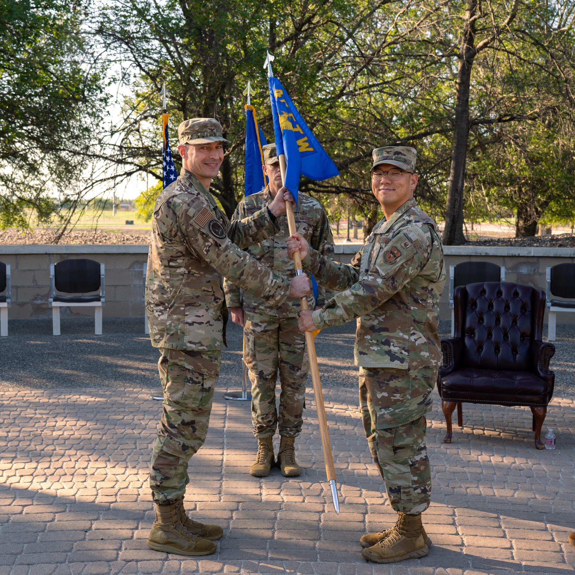 U.S. Air Force Col. Tyler Ellison (left), 47th Flying Training Wing, commander, passes the group guidon to Col. Peter Joo, incoming 47th Mission Support Group (MSG), commander, during the 47th MSG change of command ceremony at Laughlin Air Force Base, Texas, July 25, 2025. The ceremony signified the official transition of command authority within the group. (U.S. Air Force photo by Airman 1st Class Harrison Sullivan)