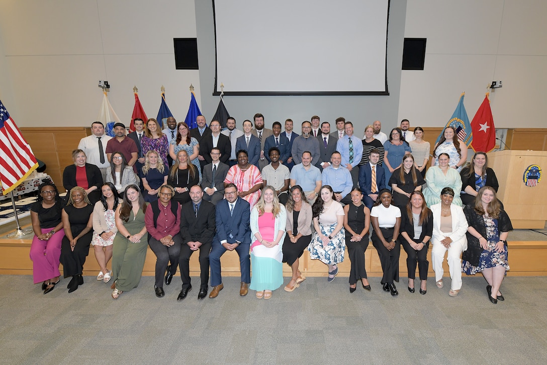 Group poses ahead of graduation reception on auditorium stage.