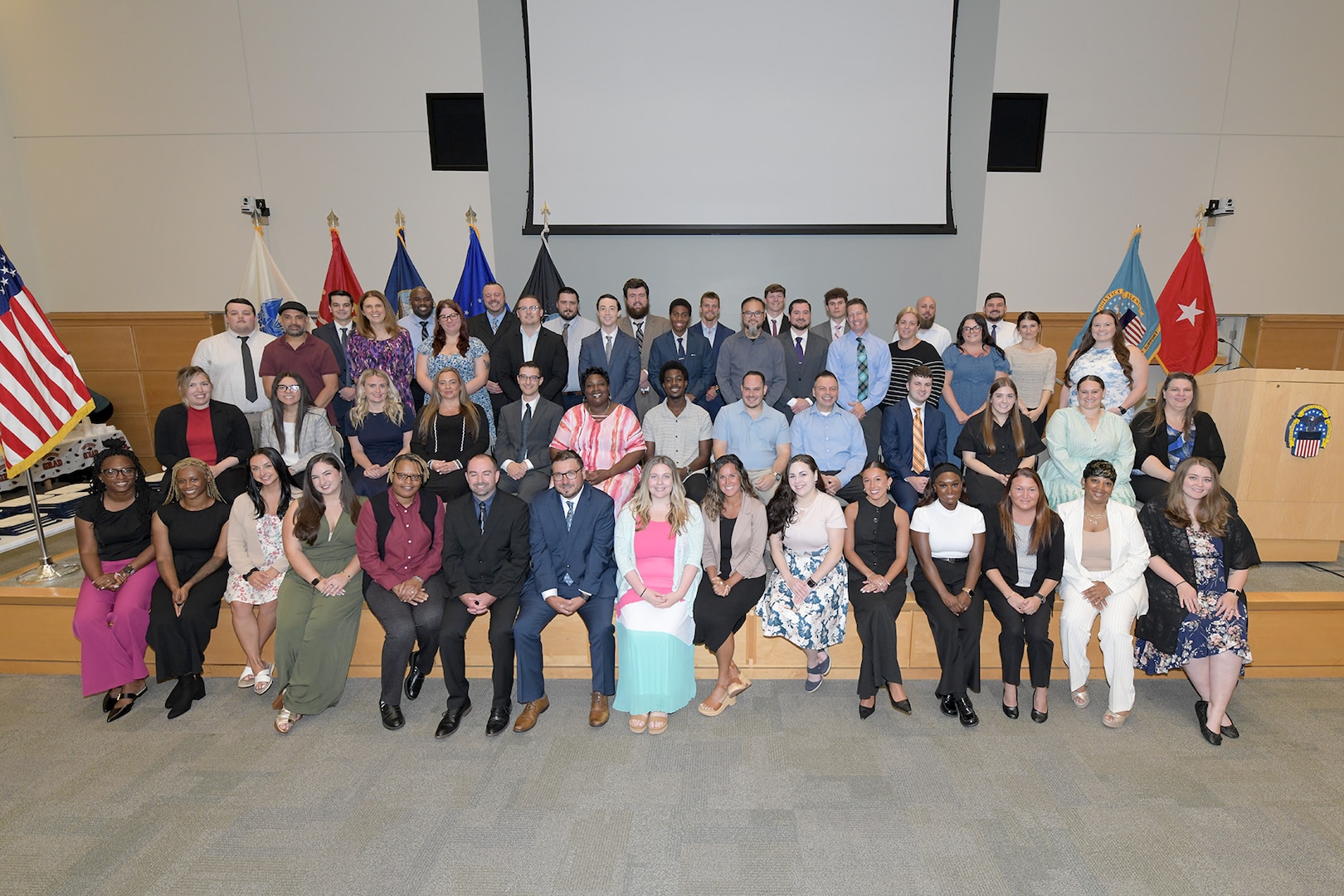 Group poses ahead of graduation reception on auditorium stage.