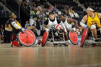 U.S. Army Retired Spc. JP Lane takes the ball up the court during a wheelchair rugby match against Team Navy at the 2025 Department of Defense Warrior Games in Colorado Springs, Colorado, July 22, 2025.
