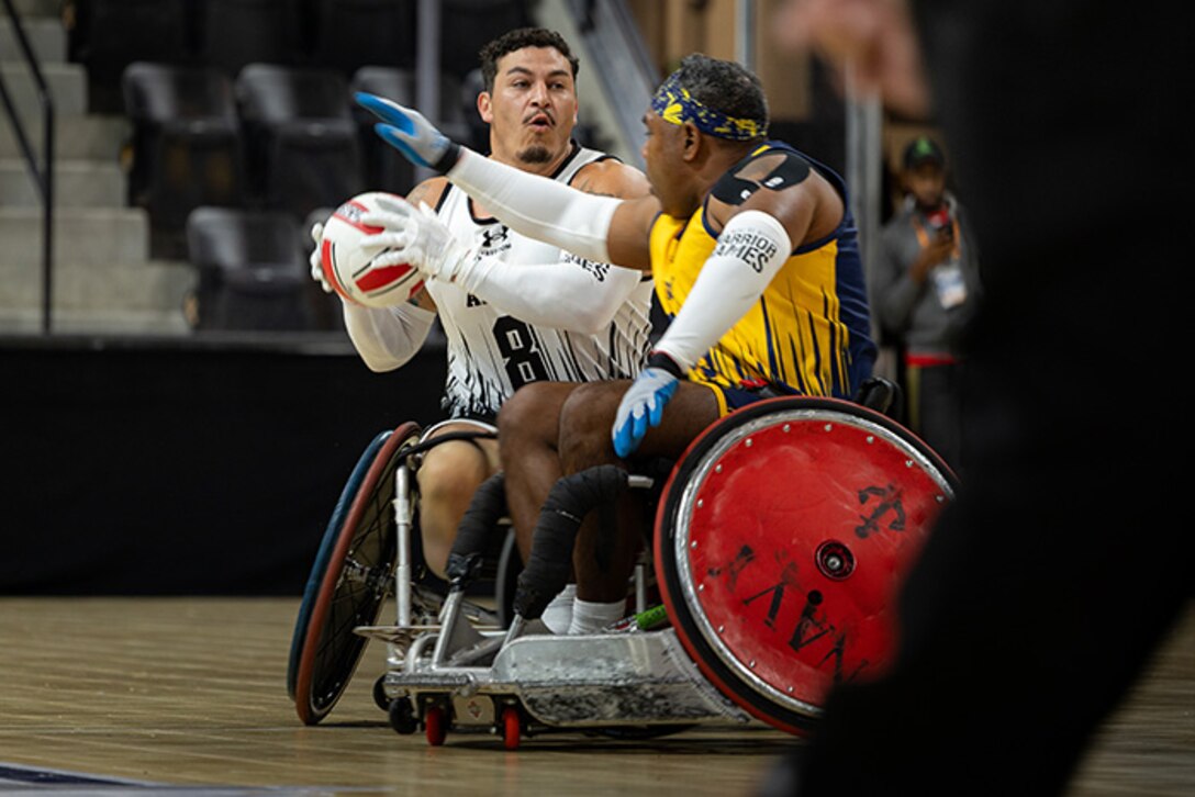 U.S. Army Retired Sgt. Jason Smith looks to pass the ball during a wheelchair rugby match against Team Navy at the 2025 Department of Defense Warrior Games in Colorado Springs, Colorado, July 22, 2025.