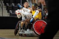 U.S. Army Retired Sgt. Jason Smith looks to pass the ball during a wheelchair rugby match against Team Navy at the 2025 Department of Defense Warrior Games in Colorado Springs, Colorado, July 22, 2025.