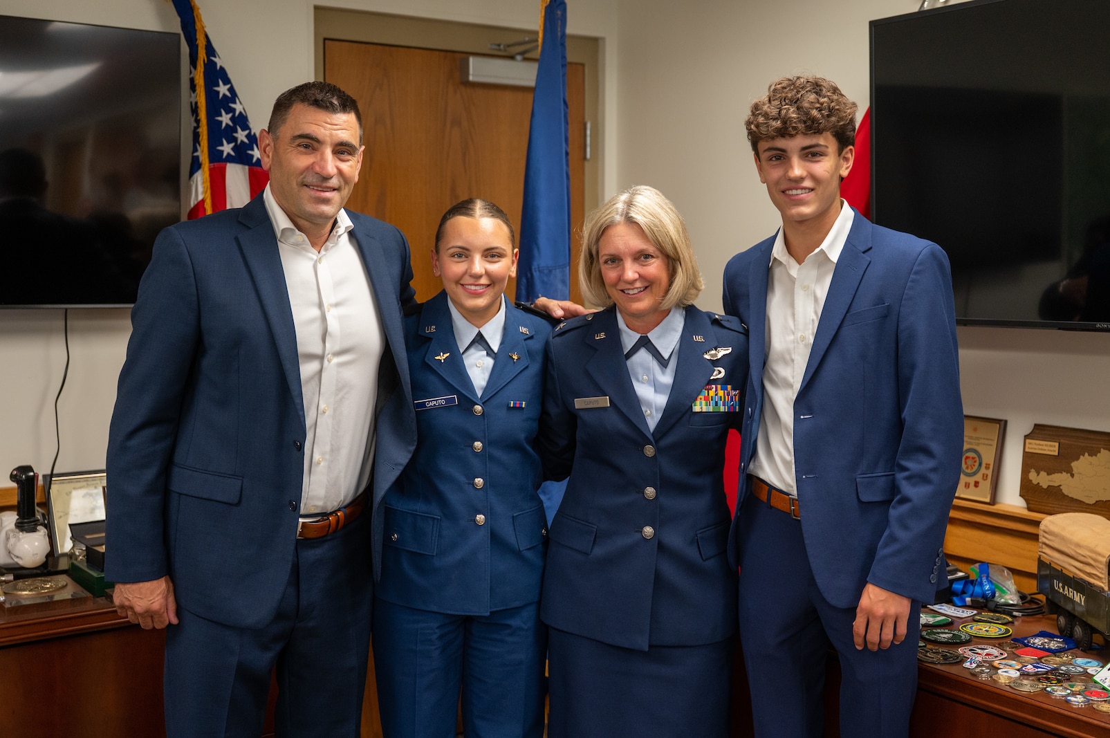 Photo of U.S. Air Force Brig. Gen. Laura Caputo (second from right) standing with her husband, retired Lt. Col. Chris Caputo (far left); her daughter, U.S. Air Force Academy Cadet, Lilly Caputo (second from left); and her son, Cal Caputo (far right), during a ceremony at Camp Johnson in Colchester,  Vermont, July 25, 2025.