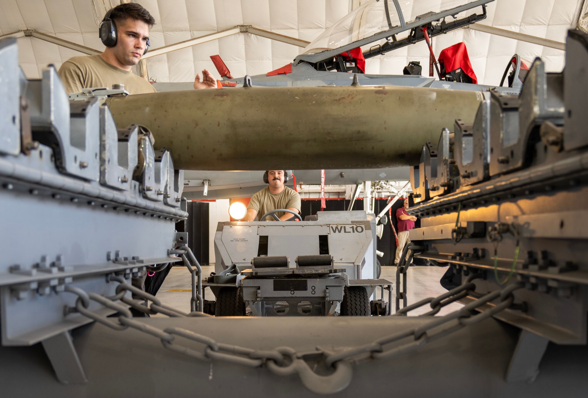 Airmen prepares a GBU-38 bomb to be loaded onto an F-15 EX.