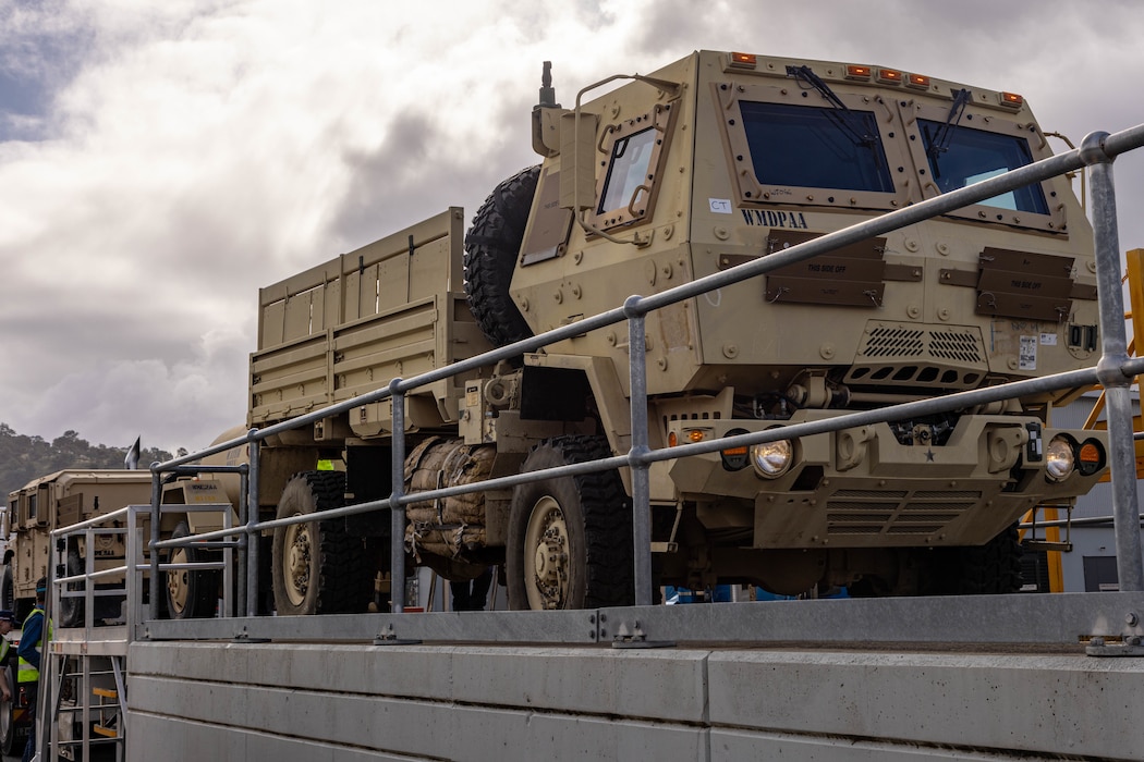 Soldiers of the 8th Theater Sustainment Command work alongside contracted civilian support to load military vehicles and equipment in preparation for exercise Talisman Sabre 25 at south Bandiana, northeast Victoria, Australia, June 15, 2025.