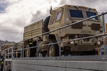 Soldiers of the 8th Theater Sustainment Command work alongside contracted civilian support to load military vehicles and equipment in preparation for exercise Talisman Sabre 25 at south Bandiana, northeast Victoria, Australia, June 15, 2025.