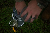 U.S. Air Force Airman 1st Class Nicholas Clark, 36th Operations Support Squadron weather apprentice and forecaster, secures a rain gauge to measure precipitation during exercise Resolute Force Pacific 2025, at Andersen Air Force Base, Guam, July 25, 2025. REFORPAC, part of the first-in-a-generation Department-Level Exercise series, trains Airmen to operate in a contested, dynamic environment while executing real-time force projection and joint interoperability. (U.S. Air Force photo by Staff Sgt. Jasmine M. Barnes)