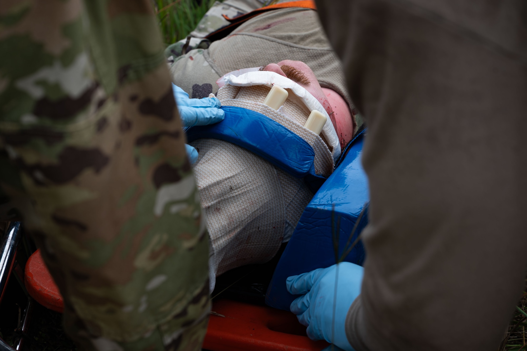 Photo of a firefighter securing gauze on a simulated casualty