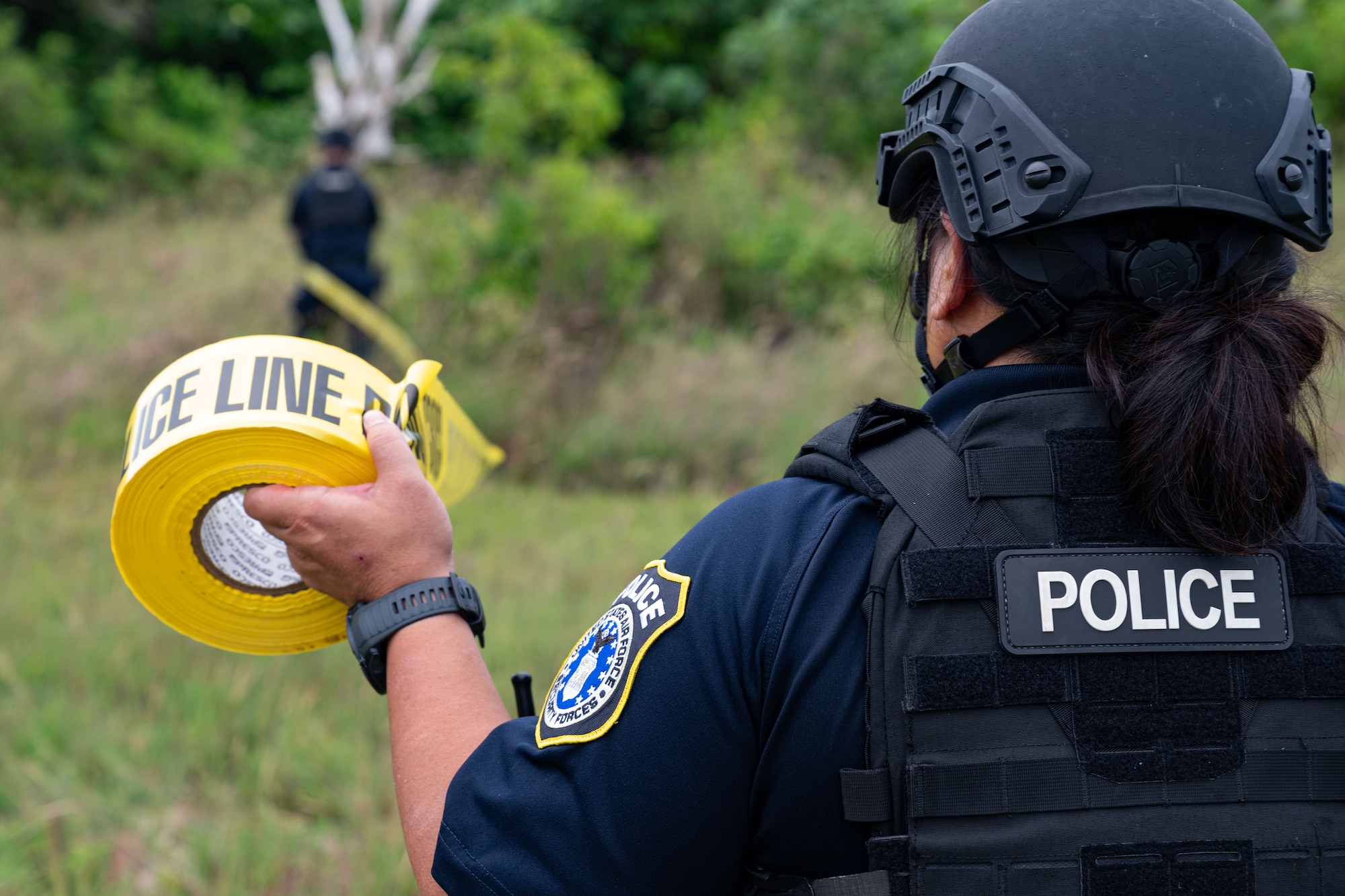Photo of a patrolman pulling caution tape