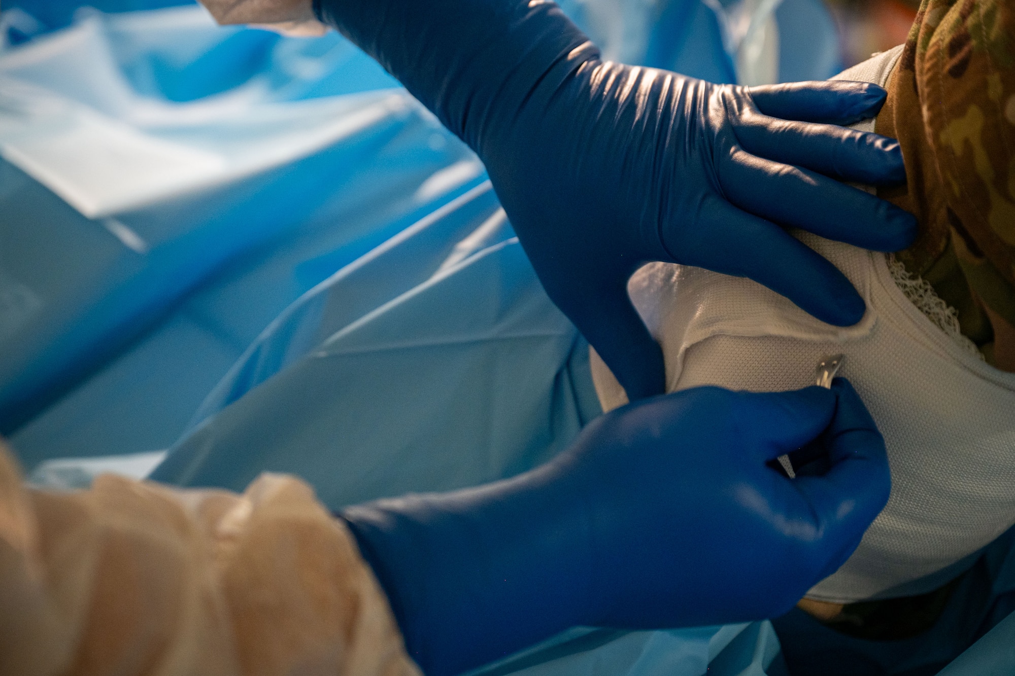 Photo of an orthopedic surgeon securing gauze on a simulated casualty's leg