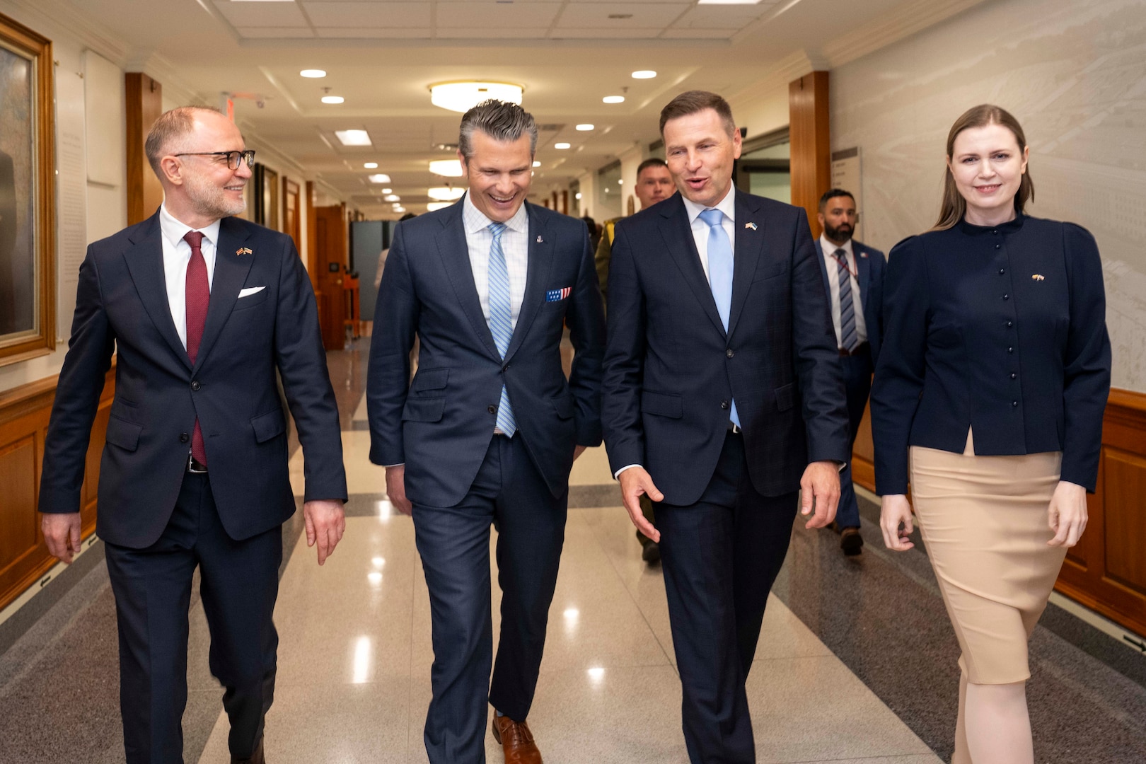 Four people walk in a hallway.