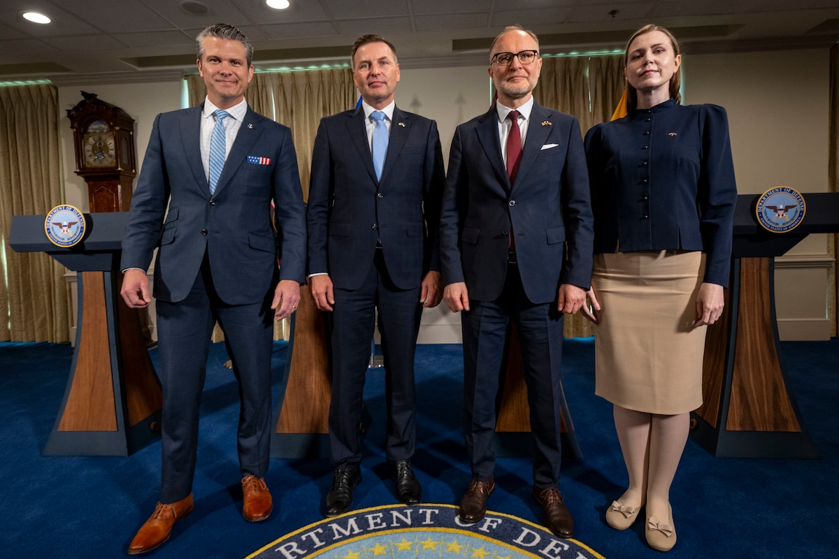 Four people pose for a photo at the Pentagon.