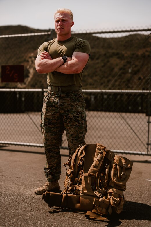 A U.S. Marine with 1st Battalion, 5th Marine Regiment, poses for a photo while standing next to a new main pack frame during a limited user evaluation at Marine Corps Base Camp Pendleton, Calif.